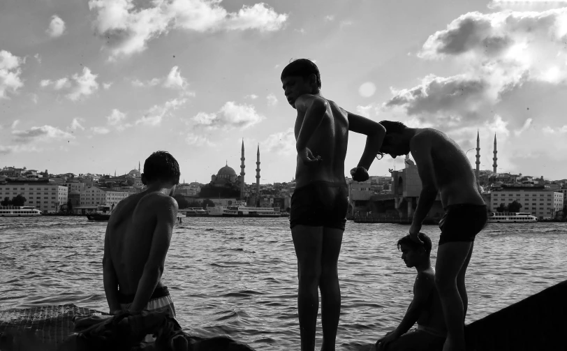 three young men standing on top of a dock