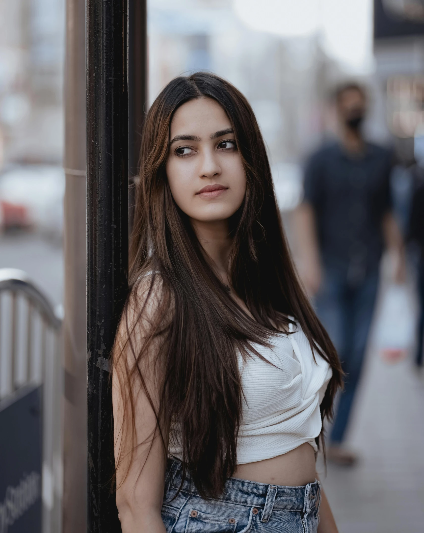 a woman leaning against a street sign