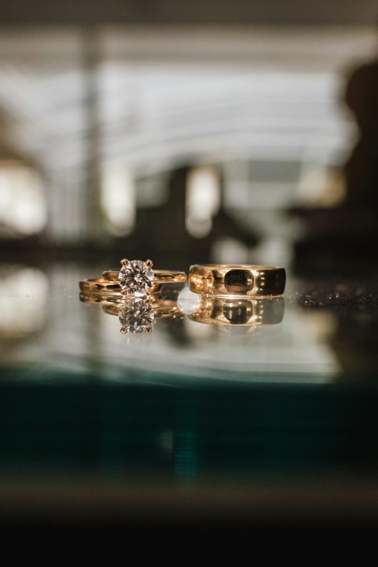 two rings sitting on top of a table in front of a mirror