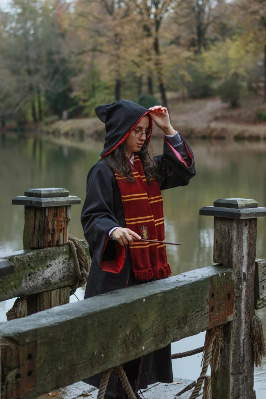 a woman in a hooded costume by a pond