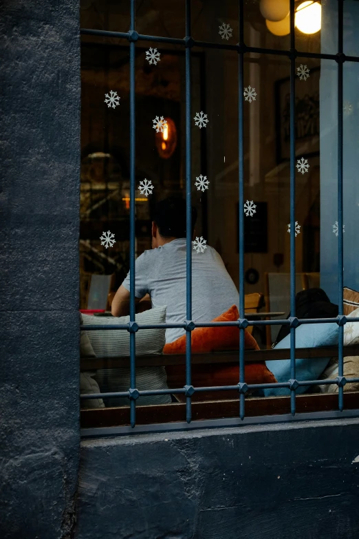 a person sitting on a chair looking out a window