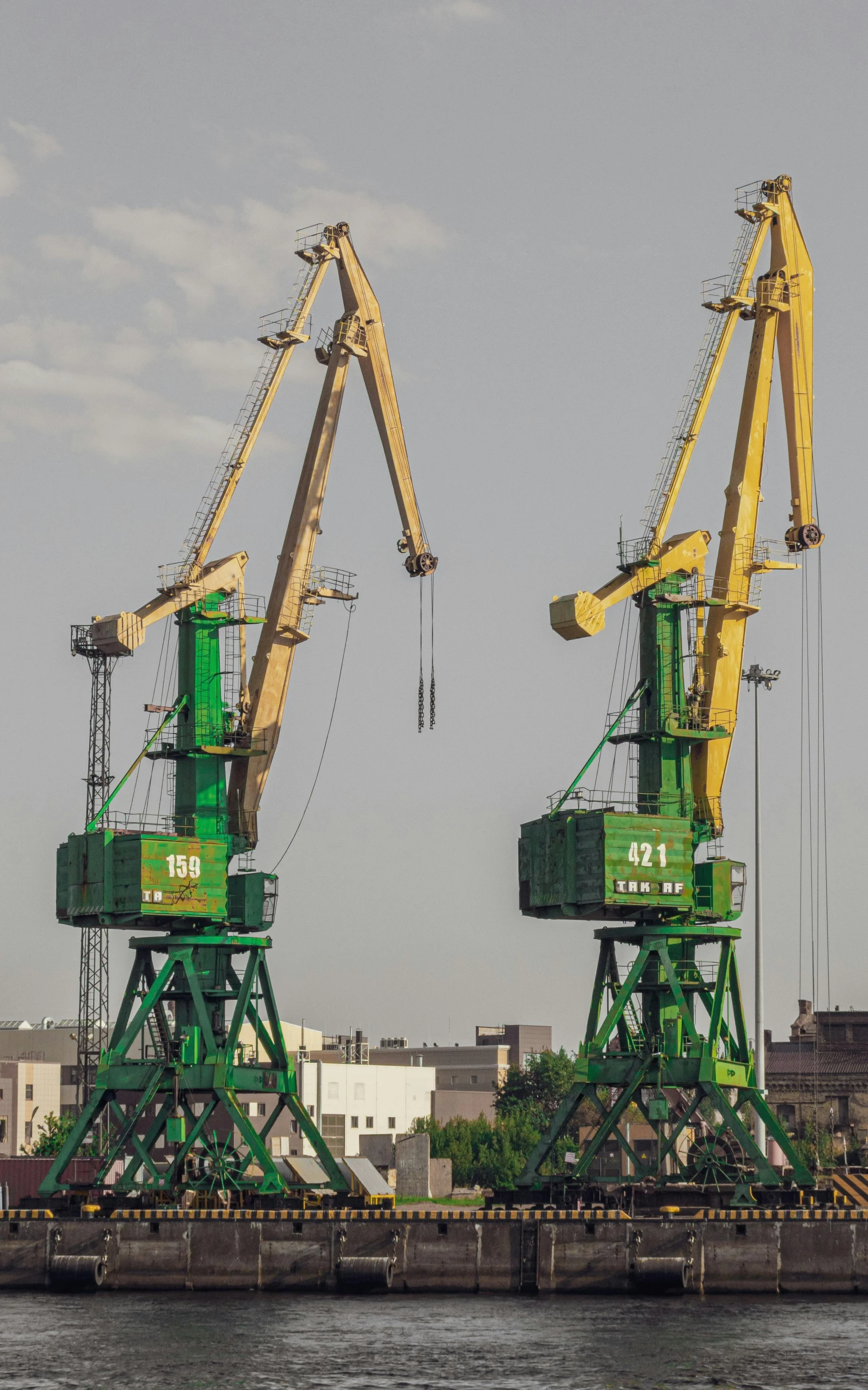 three green cranes on a boat floating in water