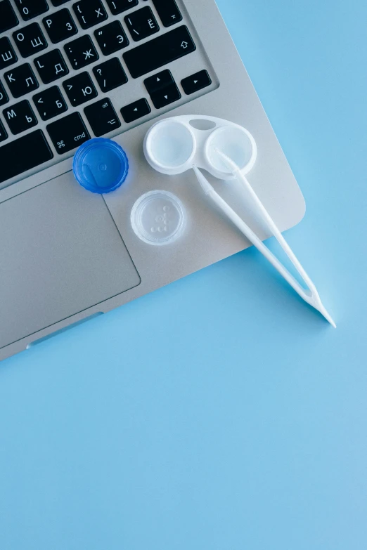 a pair of spoons sit on top of a laptop