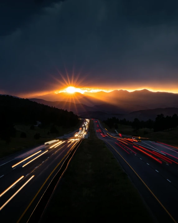 an aerial s shows a highway and mountains at sunset