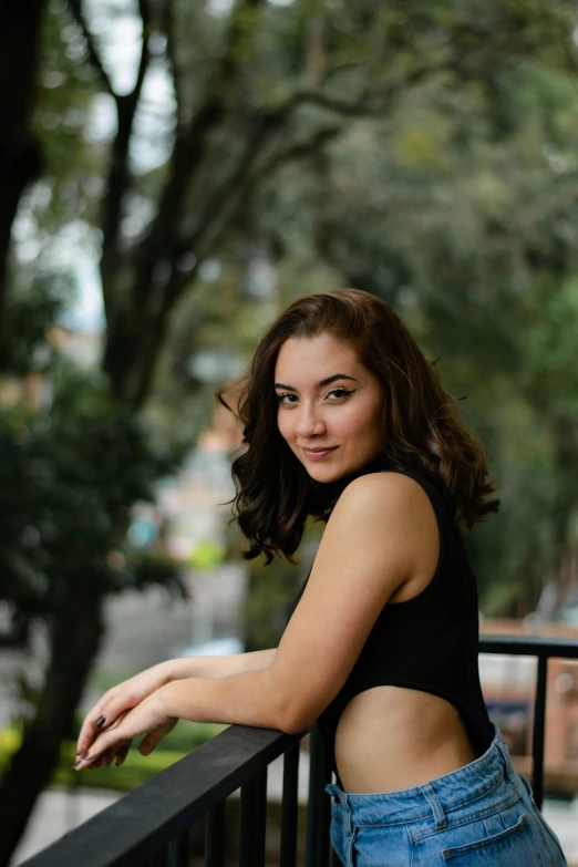 a woman leaning on a rail with her arms crossed and smiling