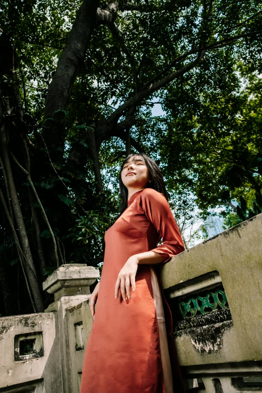 a woman standing at the edge of a stone wall