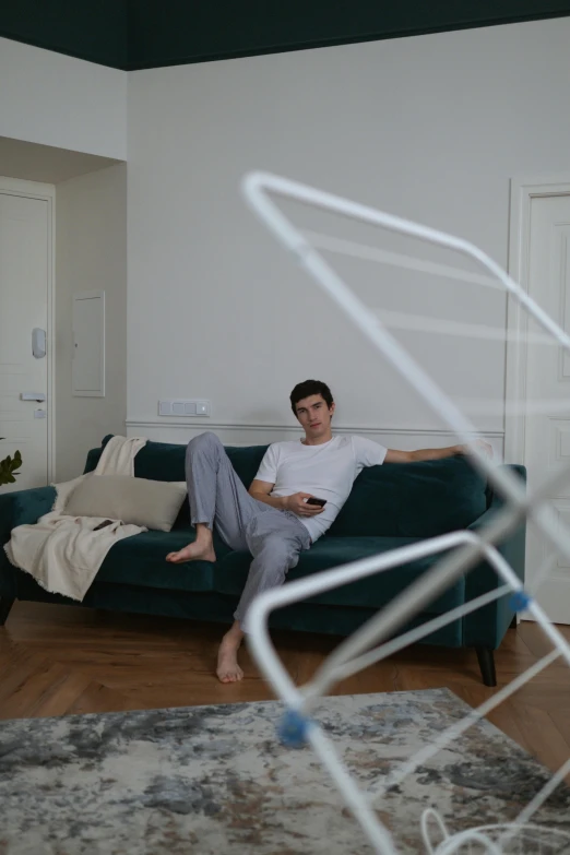 a man sitting on a couch holding a remote