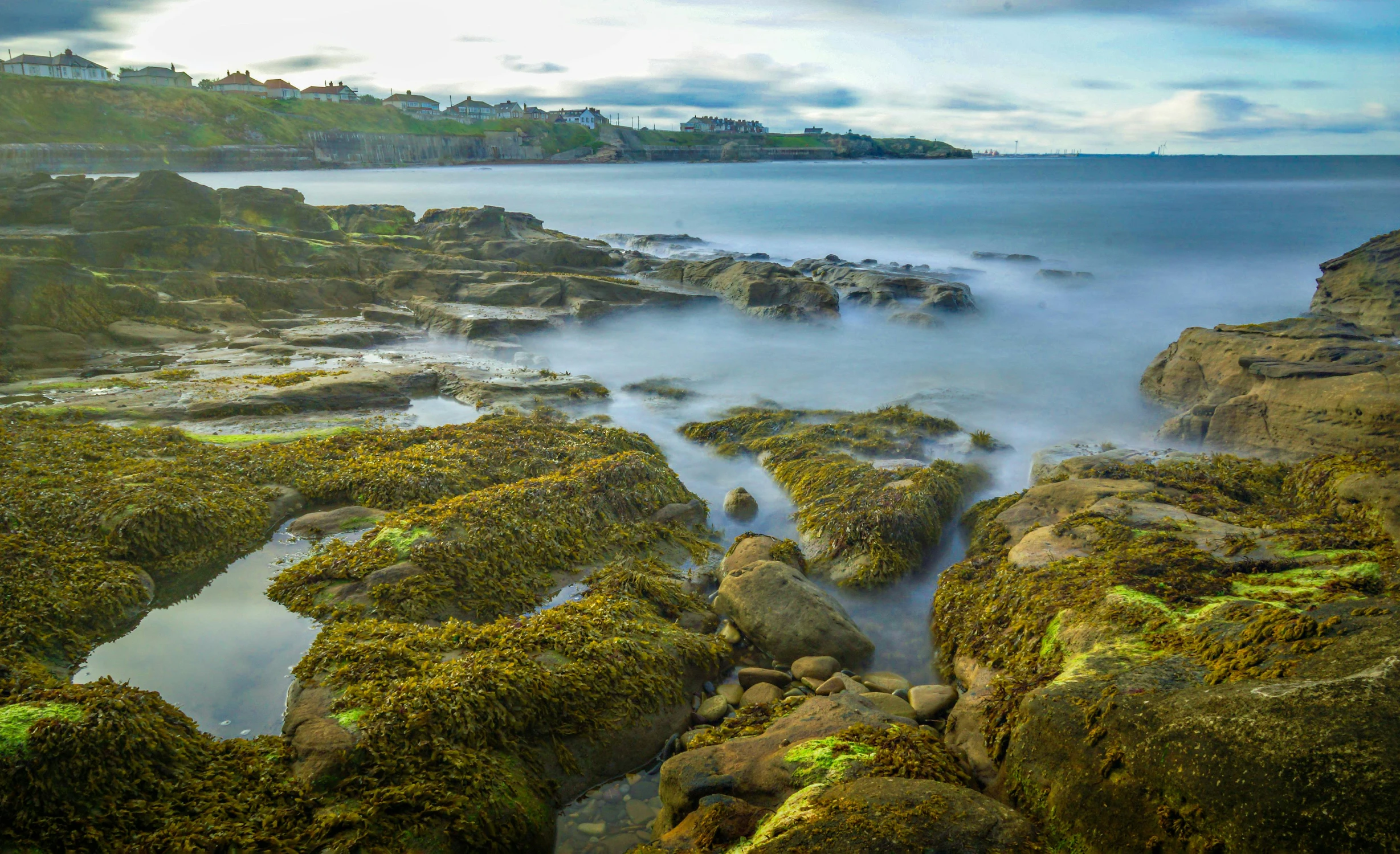 the shore line with rocks and water on it