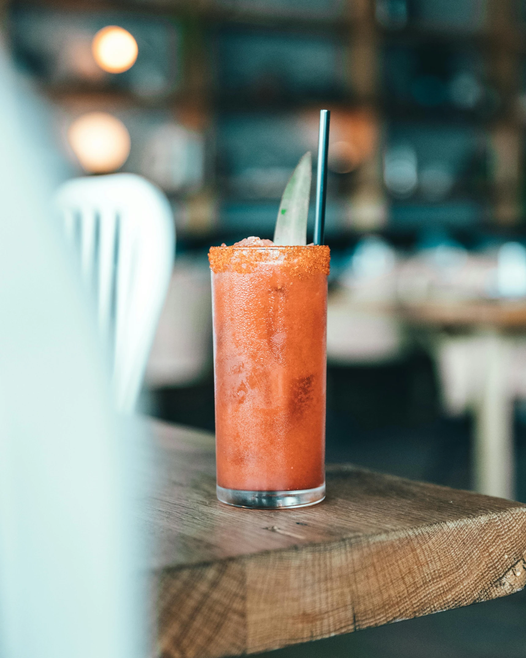 a drink sitting on top of a wooden table next to a window