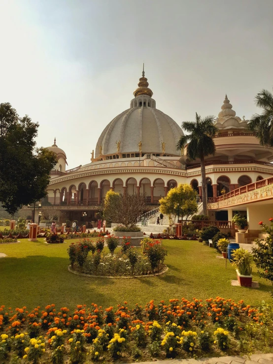 the domed building is built over looking some orange and yellow flowers