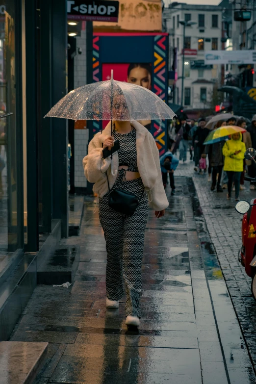 the woman is walking down the street with an umbrella