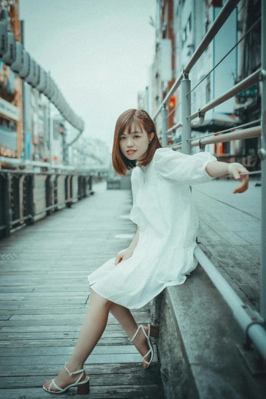 a woman is posing in a white dress