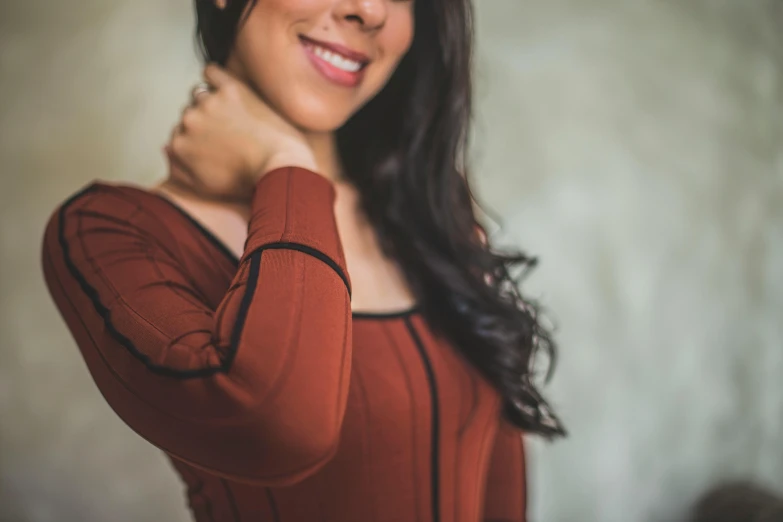 a woman holding her hands behind her neck posing