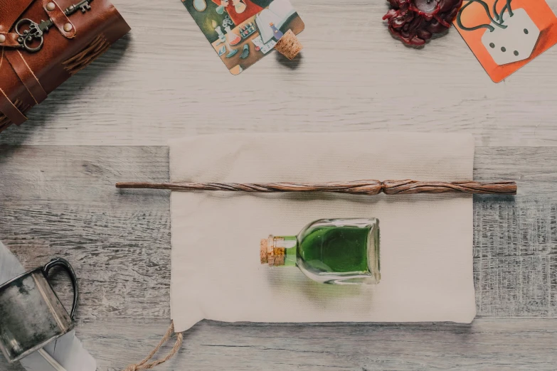 green glass bottle on a white napkin next to small papers