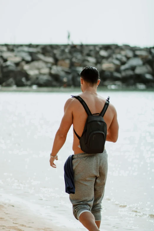 a man with  on standing in water next to a beach