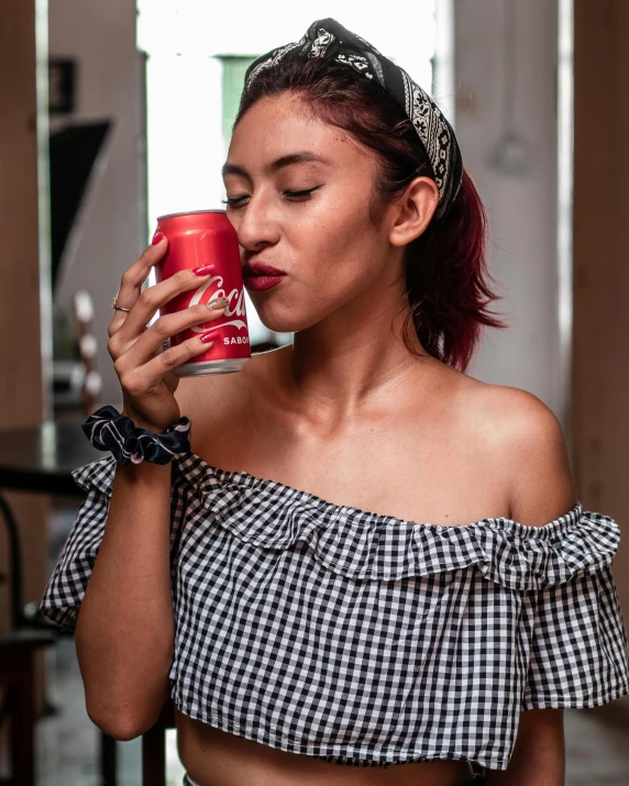 a woman sitting in front of a window holding a mug