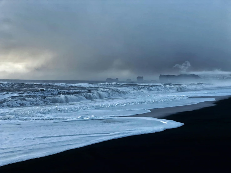 a cold day along the beach with snow and ocean waves