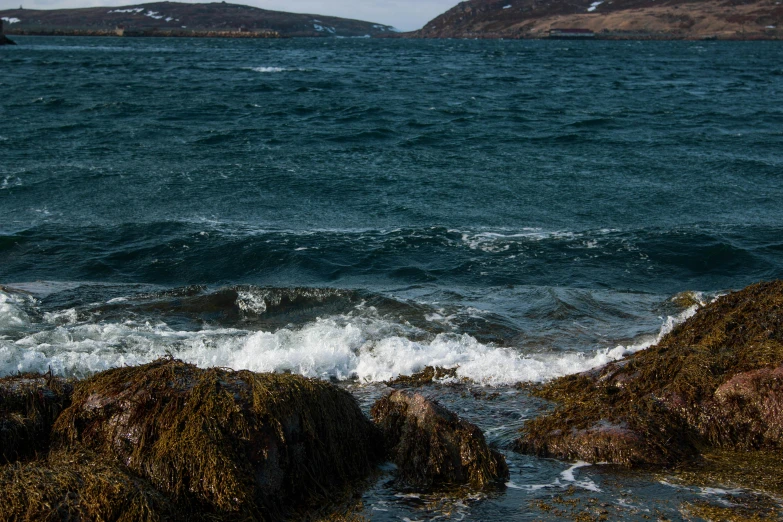 the waves in the ocean break up onto a rock shore