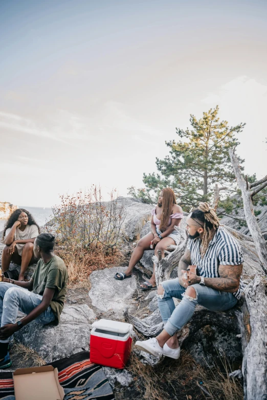 there are many people sitting on the rocks in the wilderness