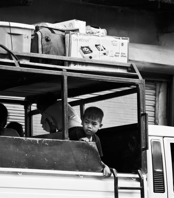 two children look out the windows of a vehicle