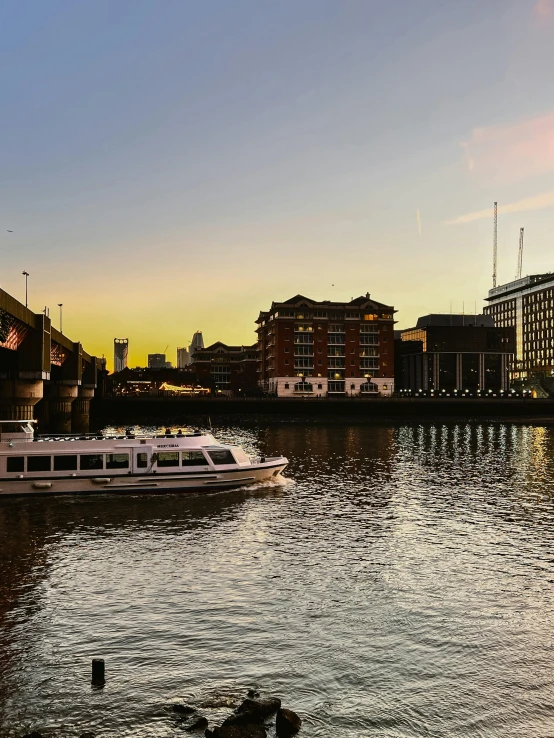 a boat traveling down a river near tall buildings