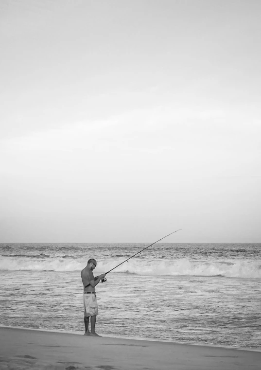 a man standing on the beach with a kite