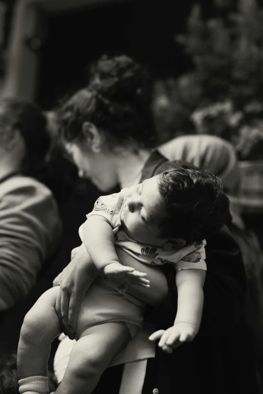 a black and white po of two people, one holding a baby