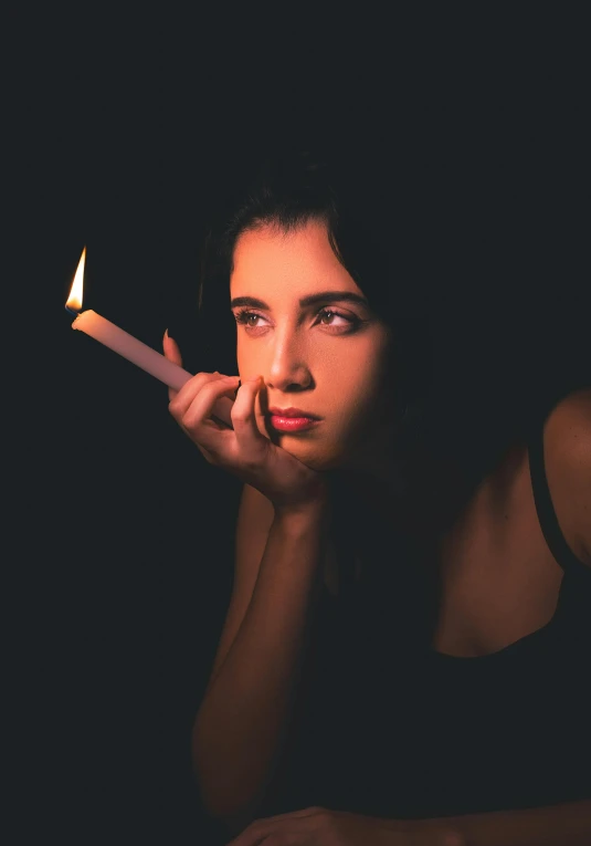 woman holding out an unlit burning candle