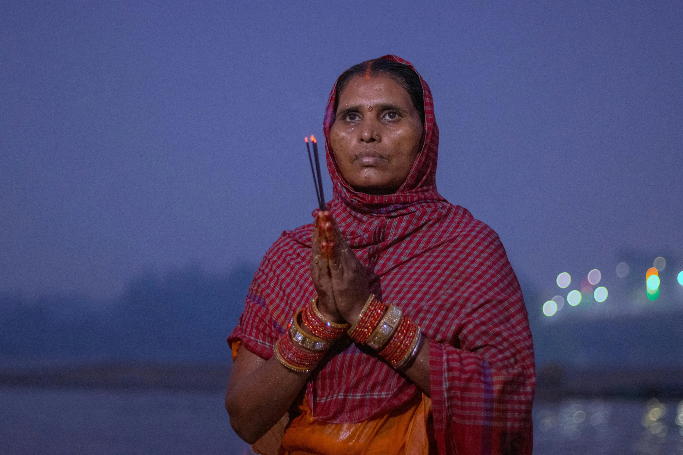 a woman in a sari is holding a flower