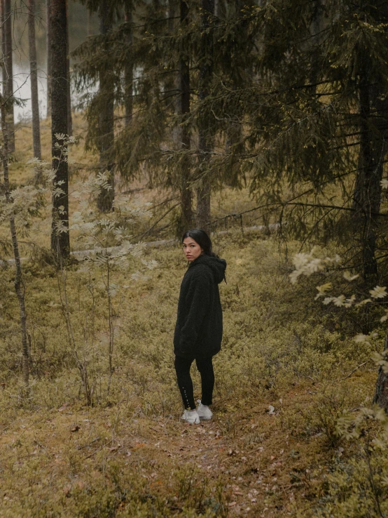 a person is walking through some grass and trees