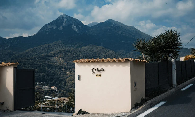 a house sitting in front of a fence with mountains in the background