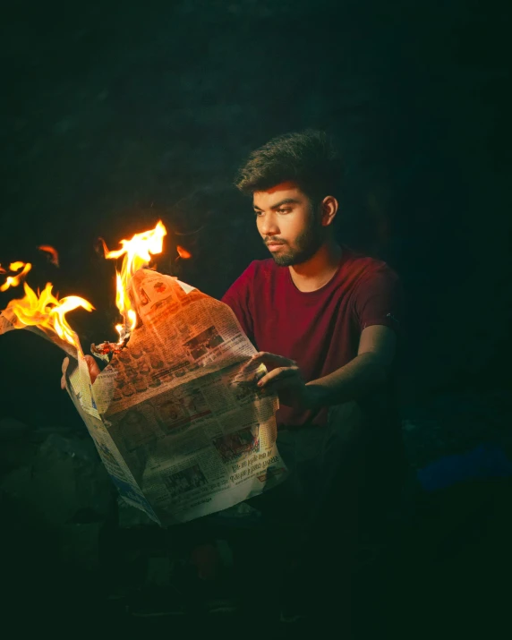 a man sitting down next to a fire extinguisher reading