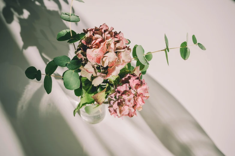 a vase with flowers in it and some green plants