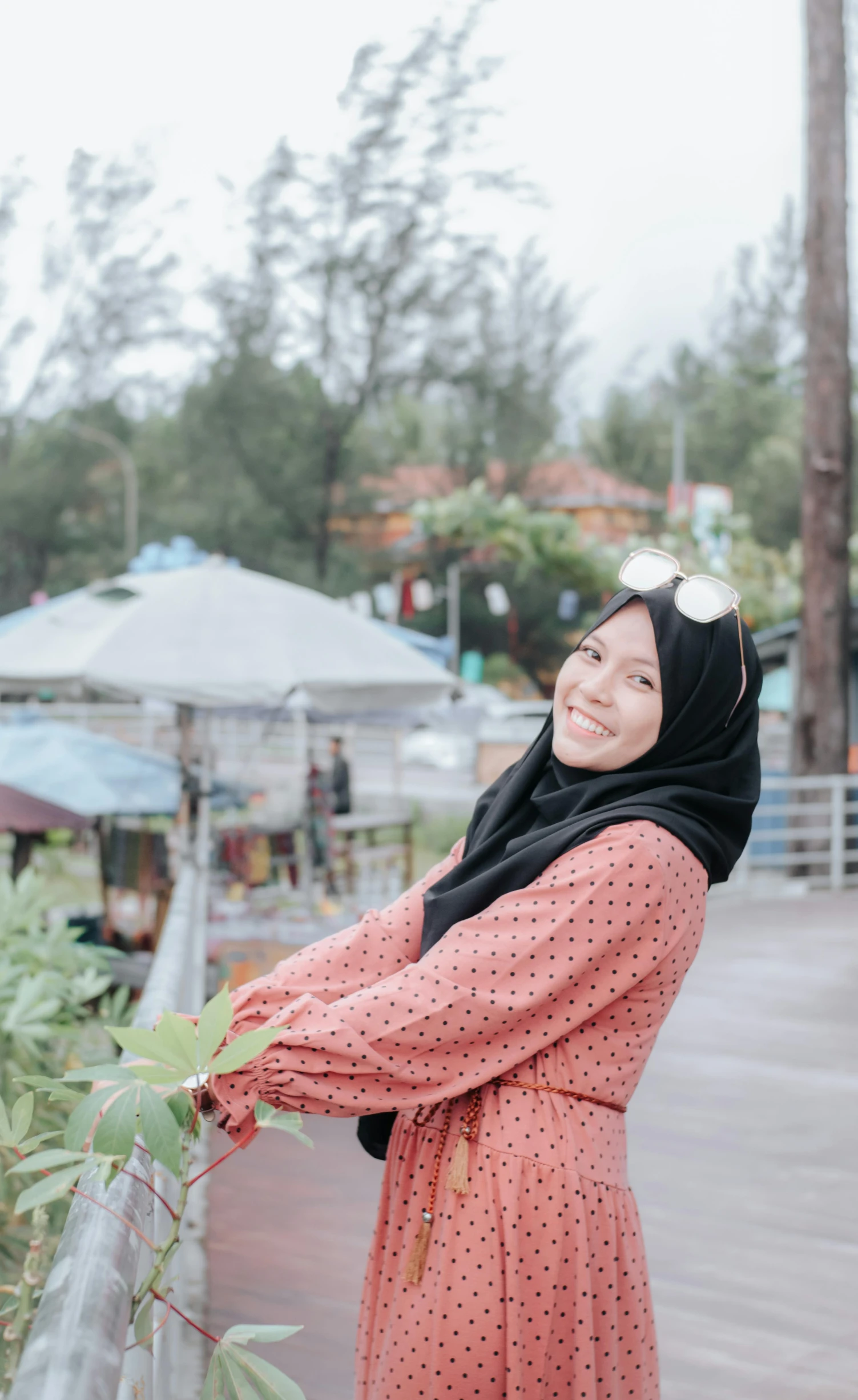 a woman with head scarf and black dots on dress