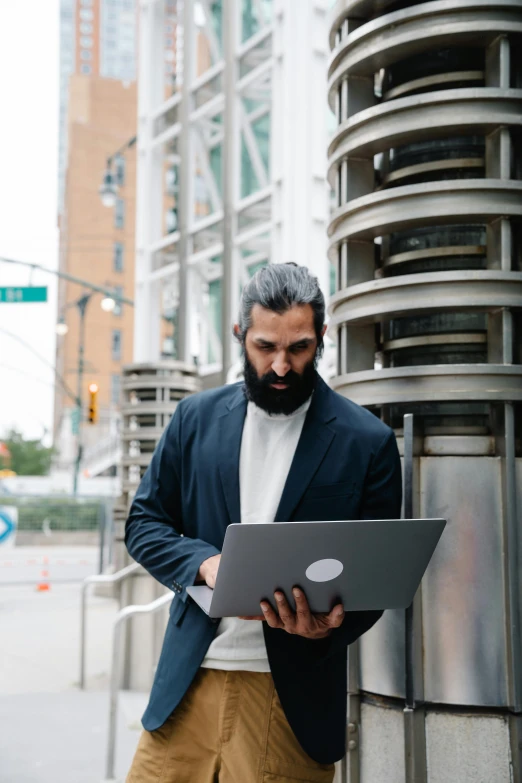 a man standing on the street looking at his computer