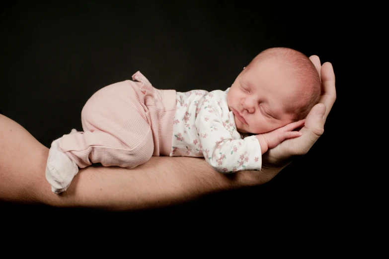 a close up of a person holding a newborn