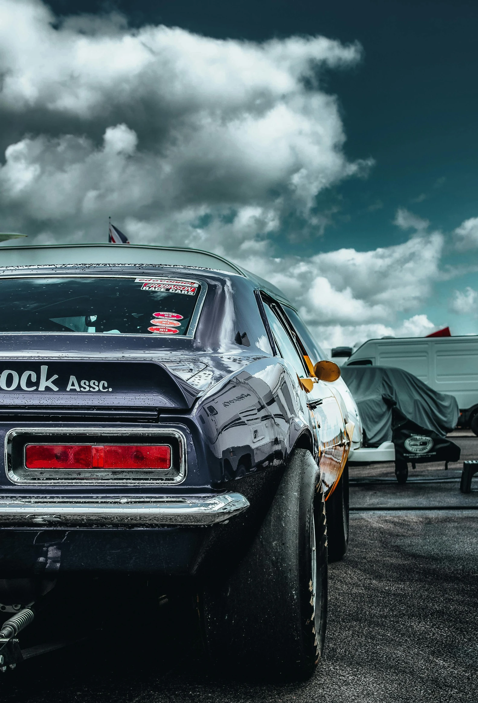 an old car is parked near the sky and clouds