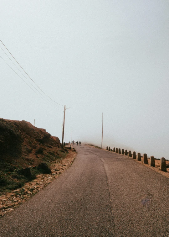 an empty road surrounded by a few large brown rocks