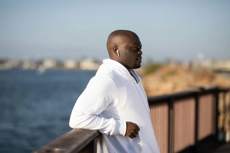 a man standing next to a wooden pier