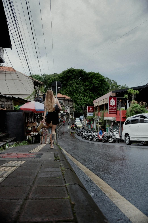 a woman is walking down the street in a city