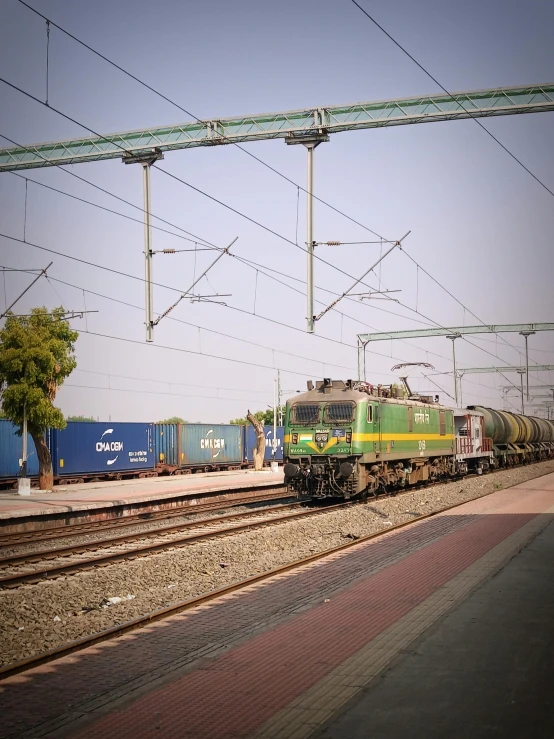 a green train is traveling on some tracks