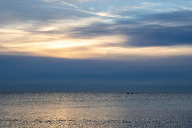 the ocean is calm with waves and some boats