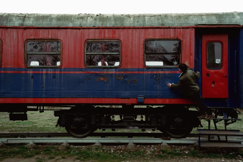 a man sitting on a red and blue train car