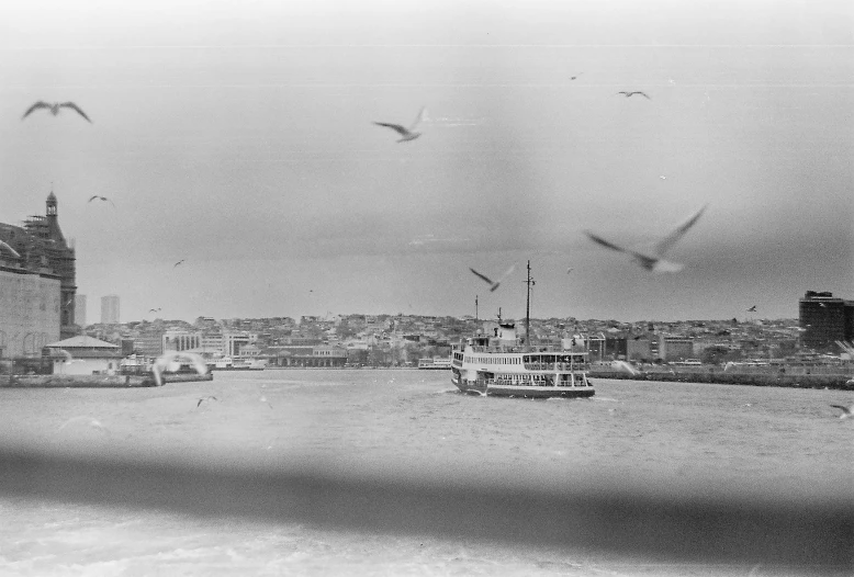 a black and white po of a boat in the water near the city