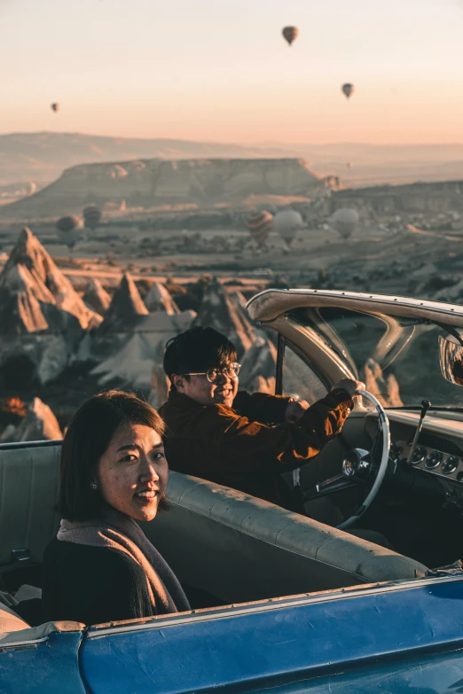 people are sitting in the back of a convertible car