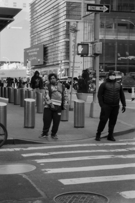 a group of people standing on the side of a road next to traffic