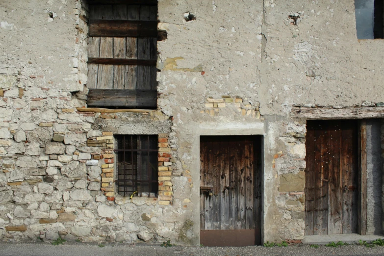 an old, run down building with wooden windows and an open door