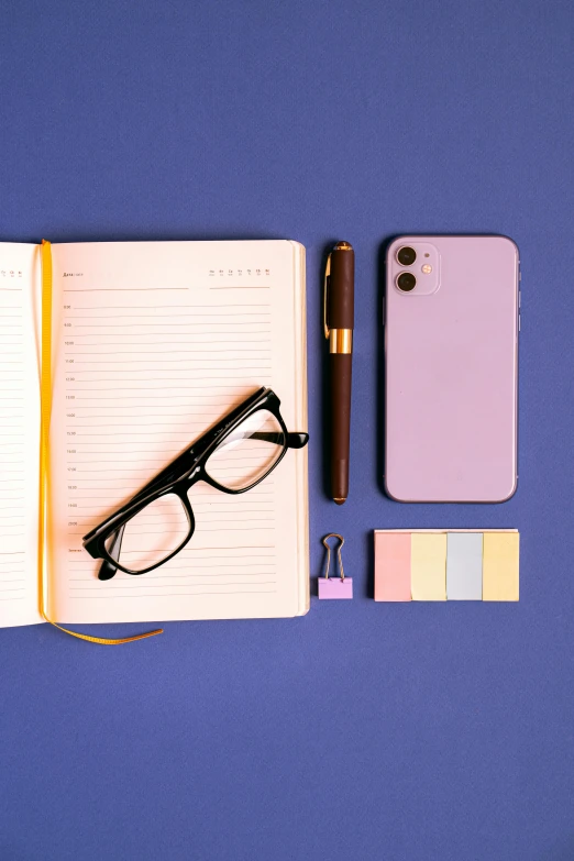 a notebook with some sticky notes and glasses on it