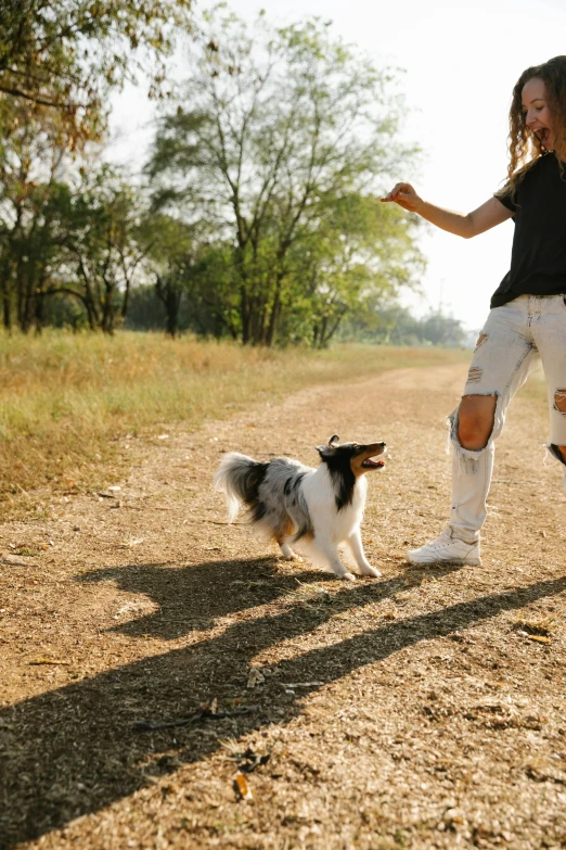 the woman is playing with her dog outside