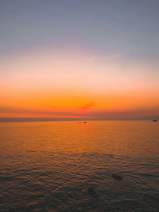 a po of the sunset and some boats in the water